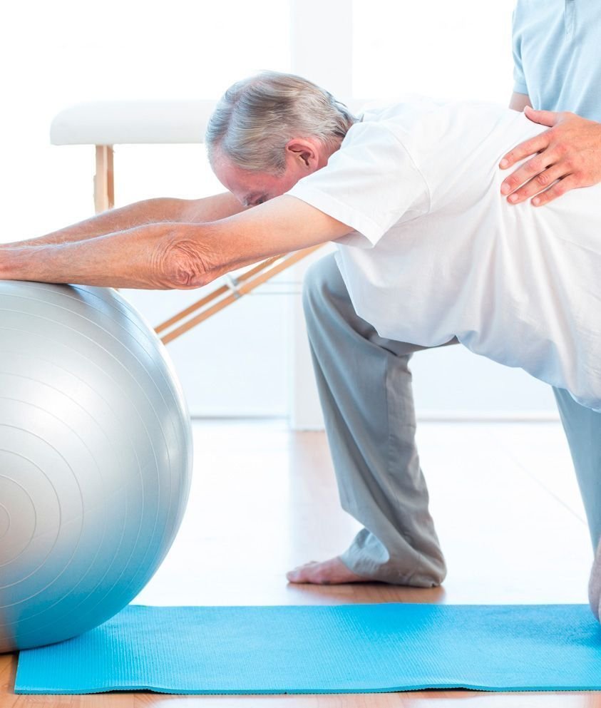 Ejercicio asistido con una pelota de rehabilitación.